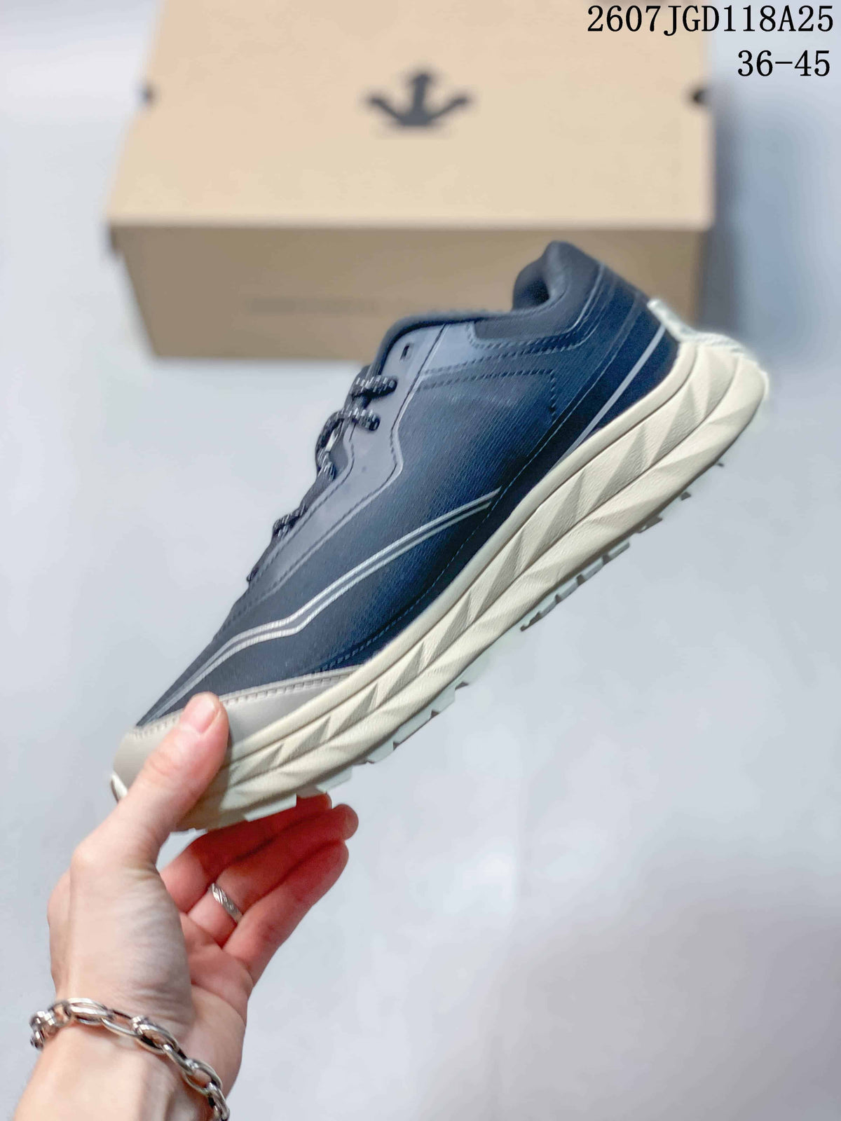 Side view of the navy low-top sneaker showing layered panels, contrast line detailing, and a cream midsole.
