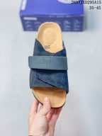 Top view of one dark sandal showing the crossover upper, broad adjustable strap and contoured footbed.