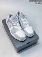 Pair of light grey and white Jordan low-top sneakers displayed on a Jordan shoebox.