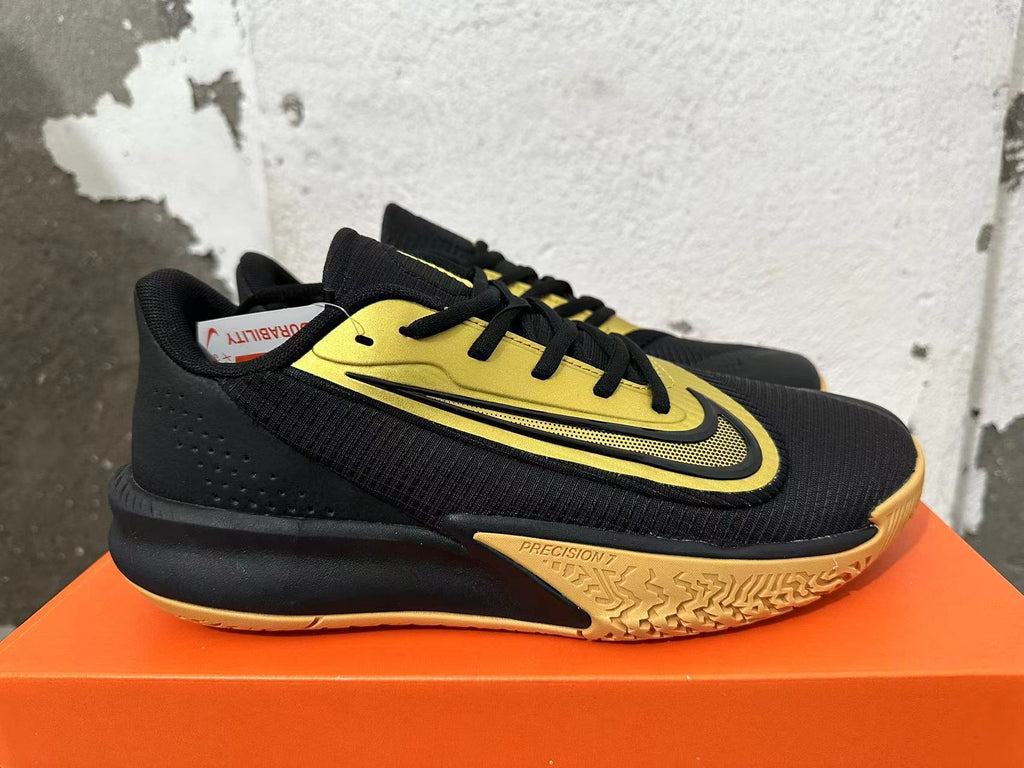 Side view of a black and gold Nike Precision 7 basketball shoe.