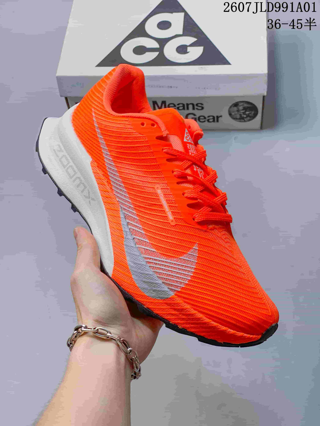 Side view of a bright orange Nike ACG trail shoe with a light midsole