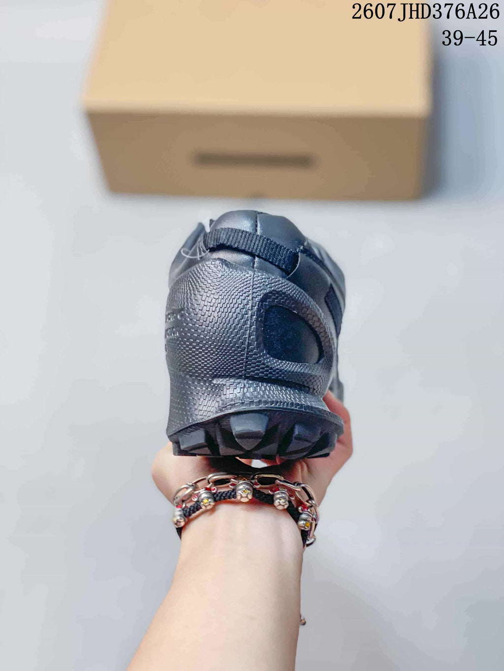 Rear view of the black sneaker showing the padded heel area and textured outsole.