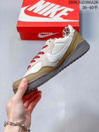 Side profile showing the cream and tan upper, red stitching details, gray midsole and textured outsole.