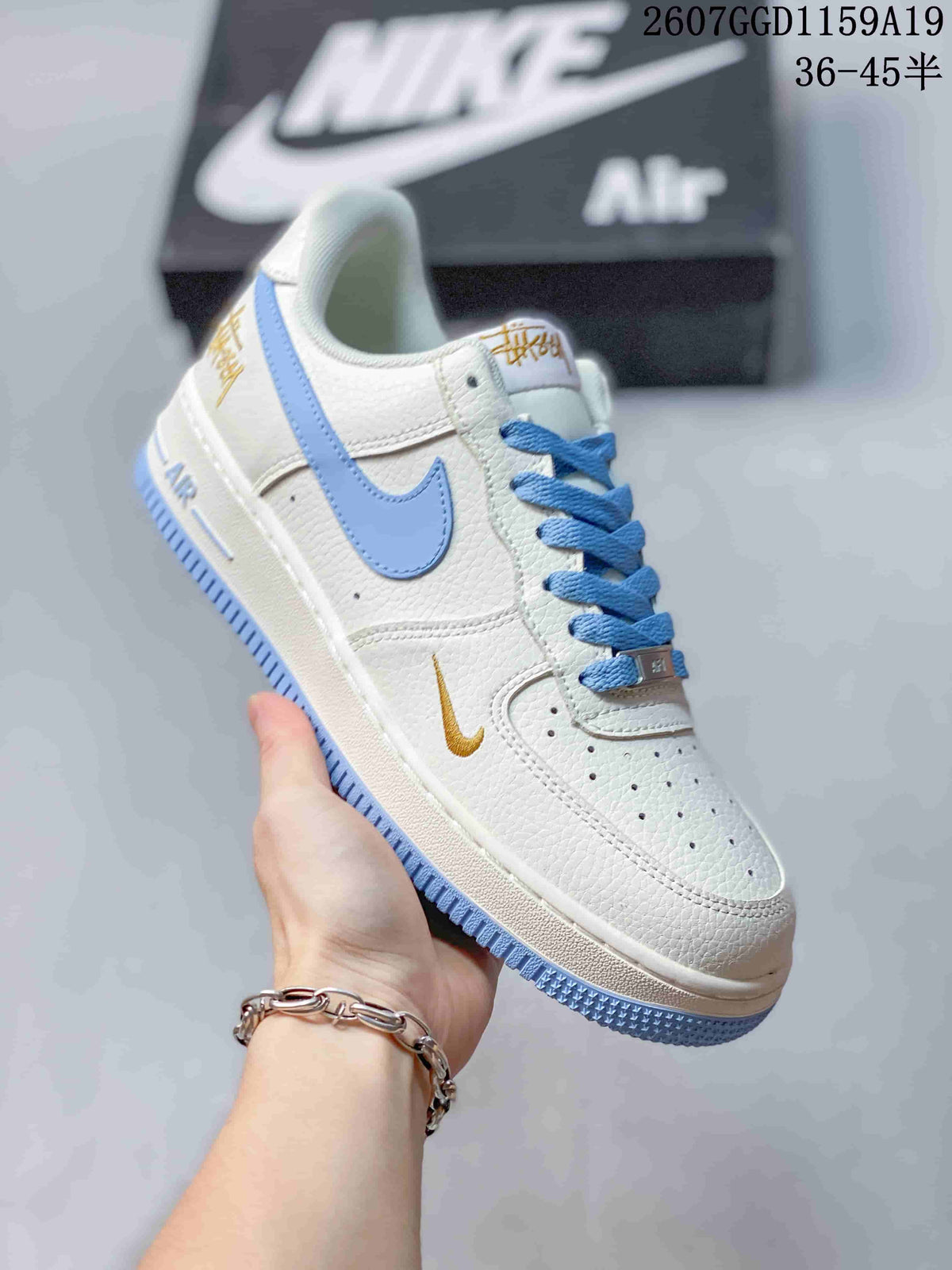 Angled side view showing the white upper, light blue Swoosh and light blue outsole accents.