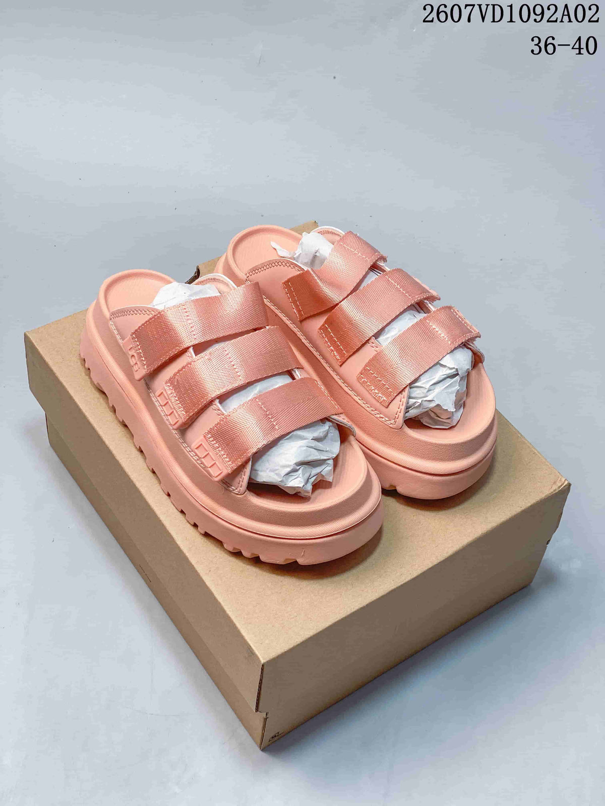 Pair of coral pink platform slide sandals with three wide straps.