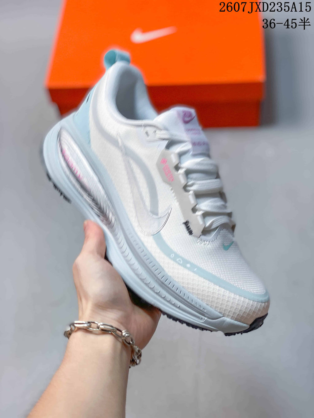 Angled side view showing the white upper, light-blue overlays, and outsole edge.