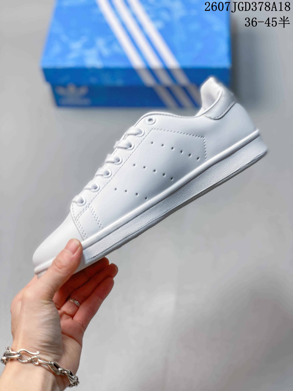 Side view showing the white upper, perforated panels, and layered sole.
