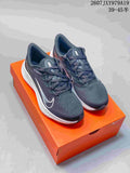 Pair of dark gray and black Nike running shoes with white accents displayed on an orange shoebox.