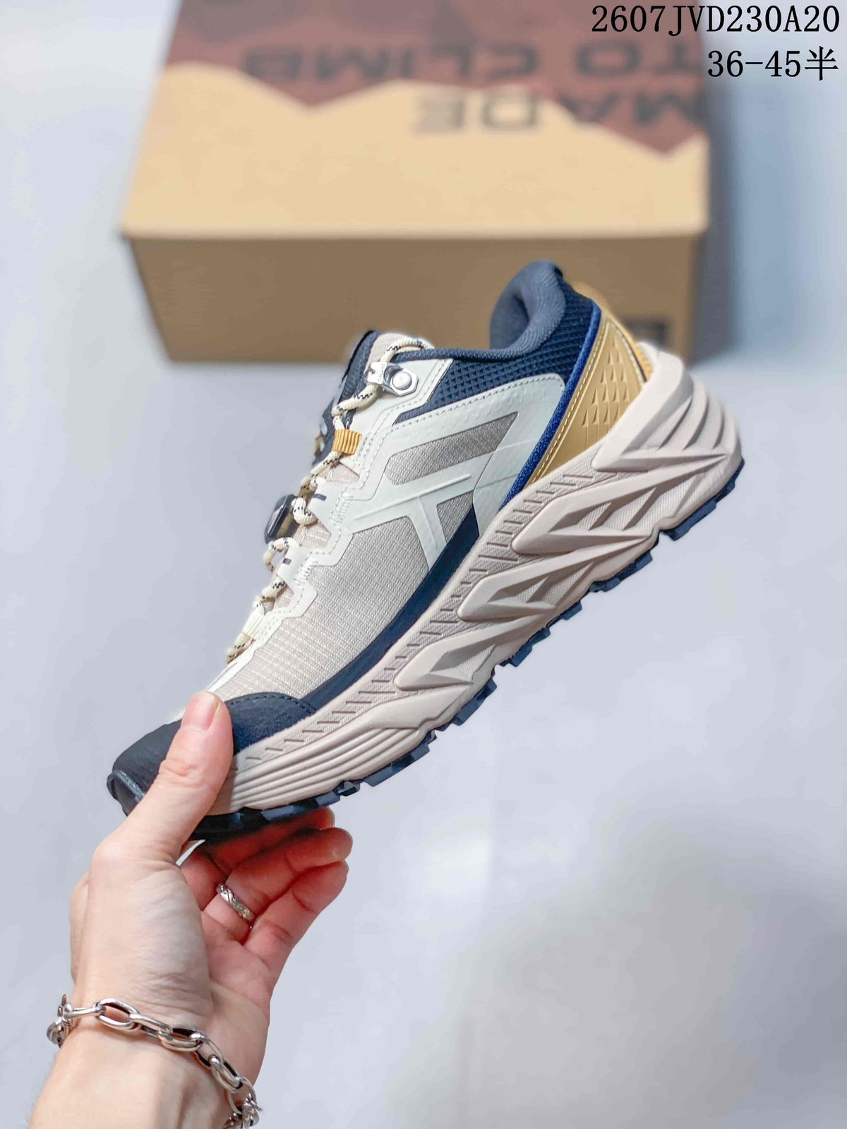 Side profile showing the low-top construction, layered upper panels, cushioned midsole, and lugged outsole.