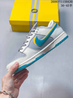 Side view of a white and gray low-top sneaker with a turquoise Swoosh-style panel and yellow trim.