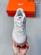 Top view of the lace-up sneaker showing the white textured upper, pink tongue detail, and dark Swoosh.