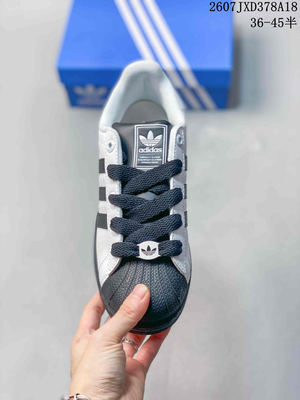 Top view of a Superstar sneaker with dark laces, a shell toe, and adidas branding on the tongue.