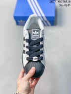 Top view of a Superstar sneaker with dark laces, a shell toe, and adidas branding on the tongue.