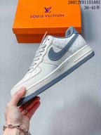 Side view of the white sneaker with gray accents and monogram-style details