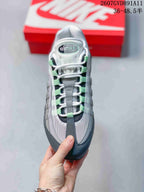 Top view showing white laces, green lace loops, layered gray panels, and an Air Max tongue label.