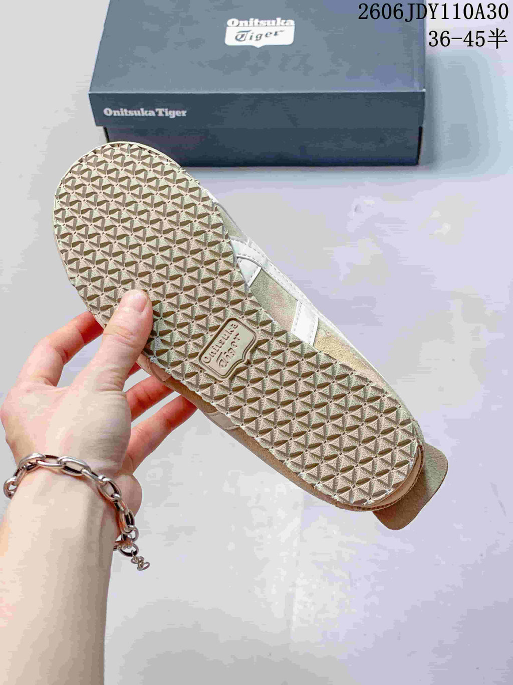 Close-up of the textured outsole and shoebox of beige Onitsuka Tiger sneakers