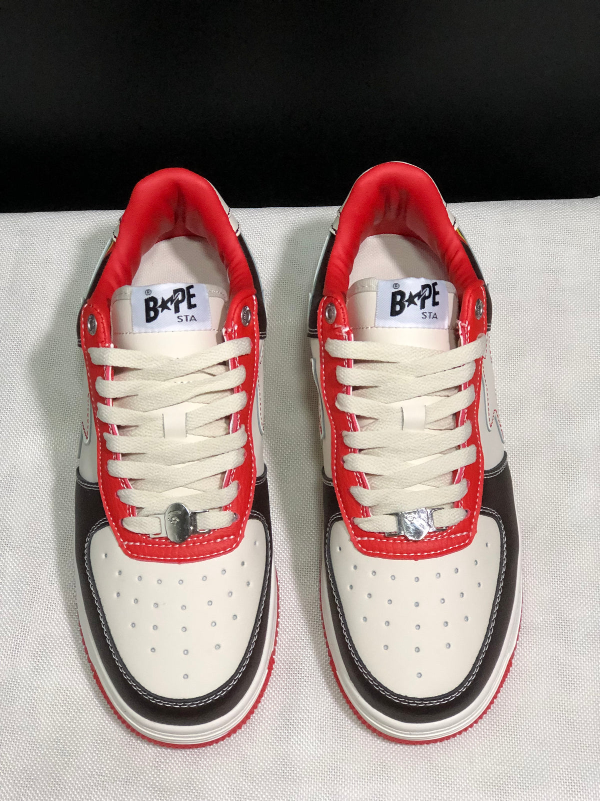 Front top view showing the lacing, perforated toe boxes, contrast black overlays, and BAPE STA tongue labels.