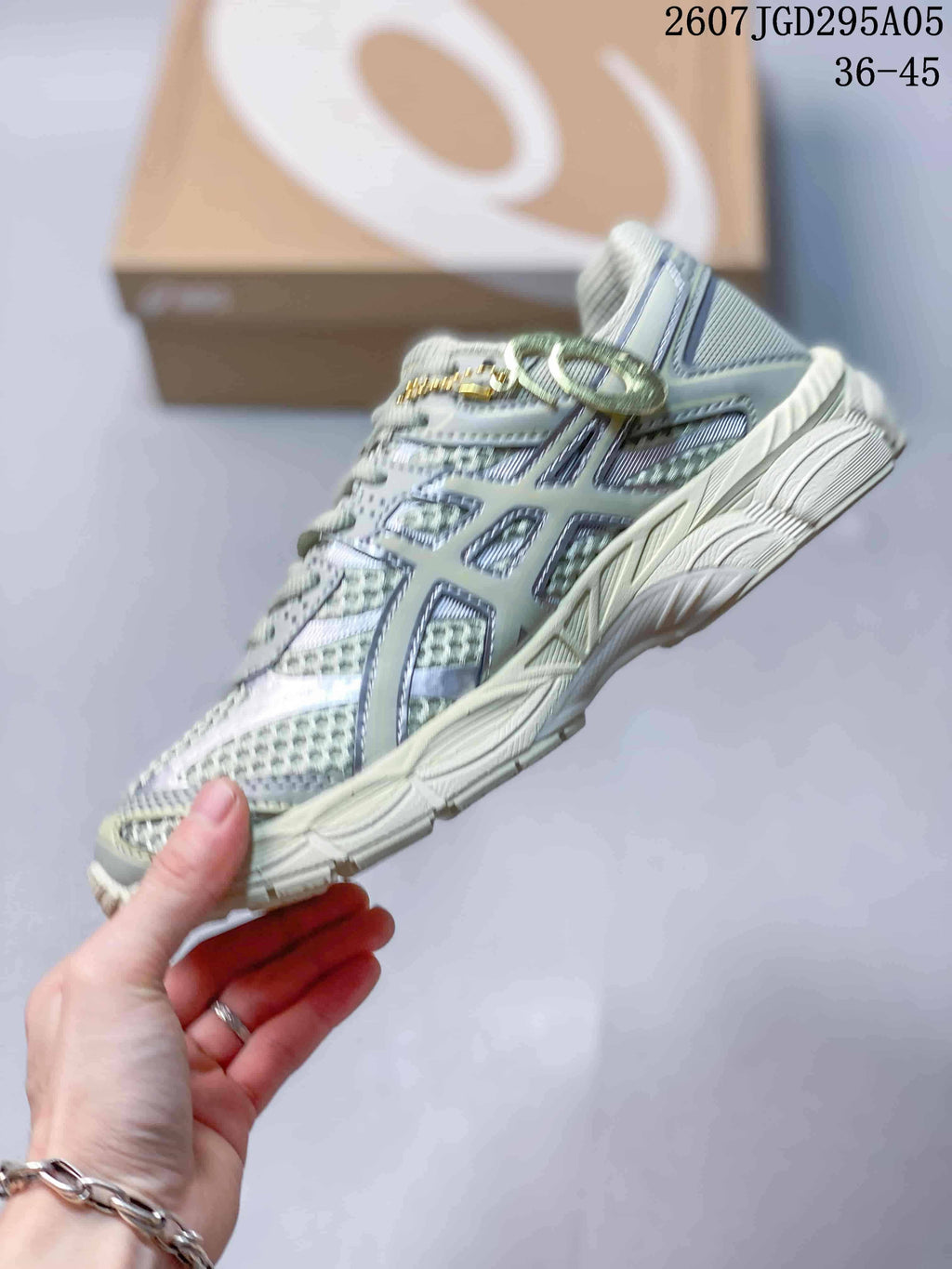 Side profile of the pale mint and gray sneaker showing mesh-style panels, structural overlays, laces, and the raised midsole; overlay text shows style code 2607TGD295A05 and size range 36–45.