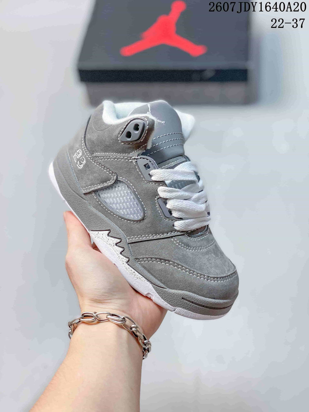 Gray kids' mid-top sneaker with white laces, gray overlays, and a light outsole.