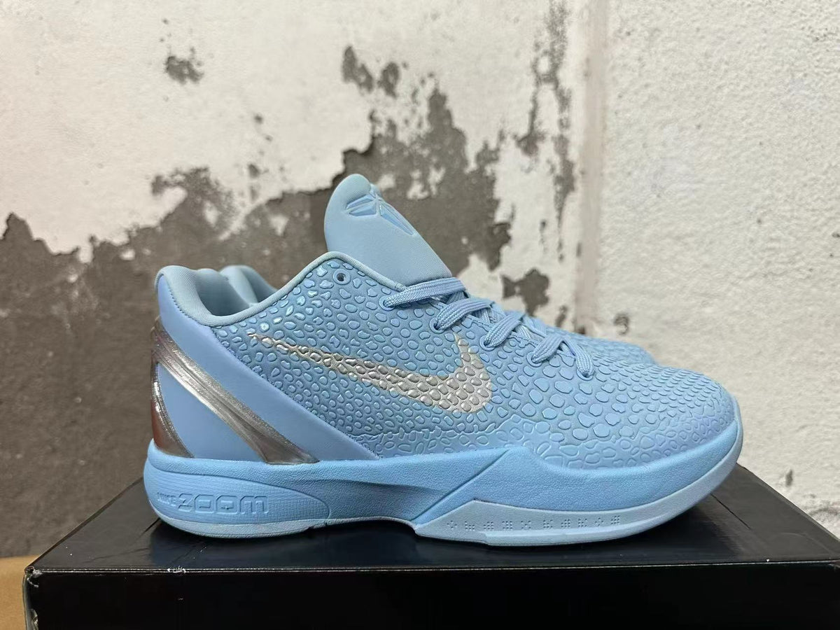 Side view of a light blue Nike basketball shoe with a textured upper, silver-tone Swoosh and sculpted sole.