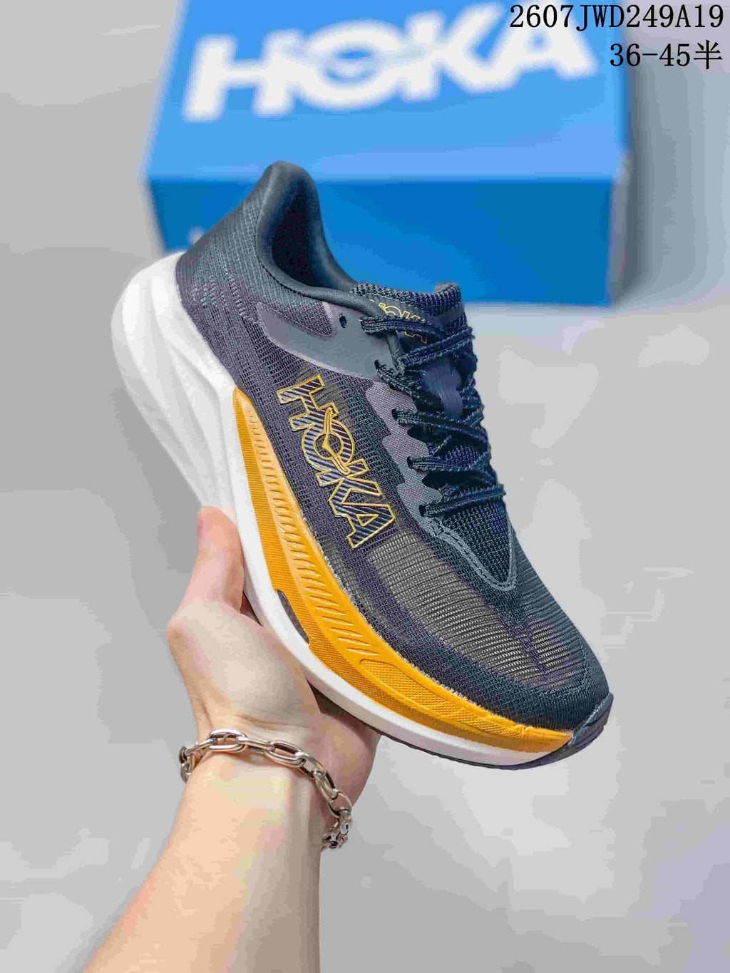 Dark gray Hoka One One MAFATE X shoe with yellow side and sole accents.