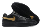 Black Nike Ja 1 shoes with gold-colored side detailing and a black outsole.