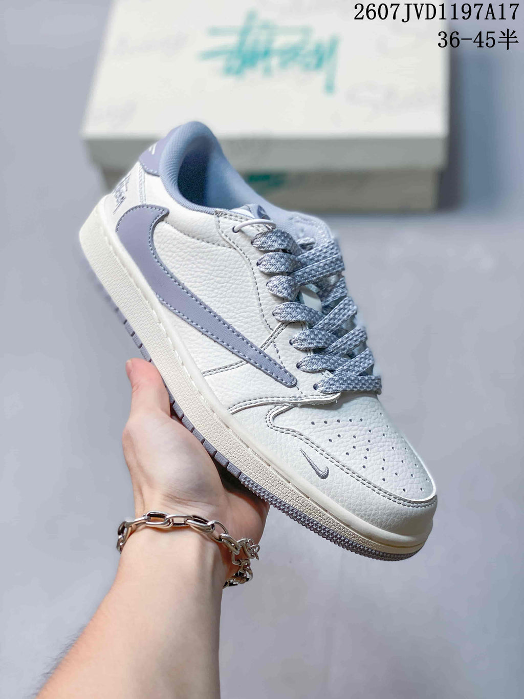 Angled side view showing the white and grey upper, perforated toe box, grey Swoosh, and rubber sole.
