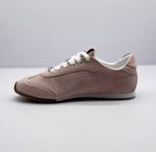 Opposite side view showing the pink sneaker's stitched panels and low-profile shape.
