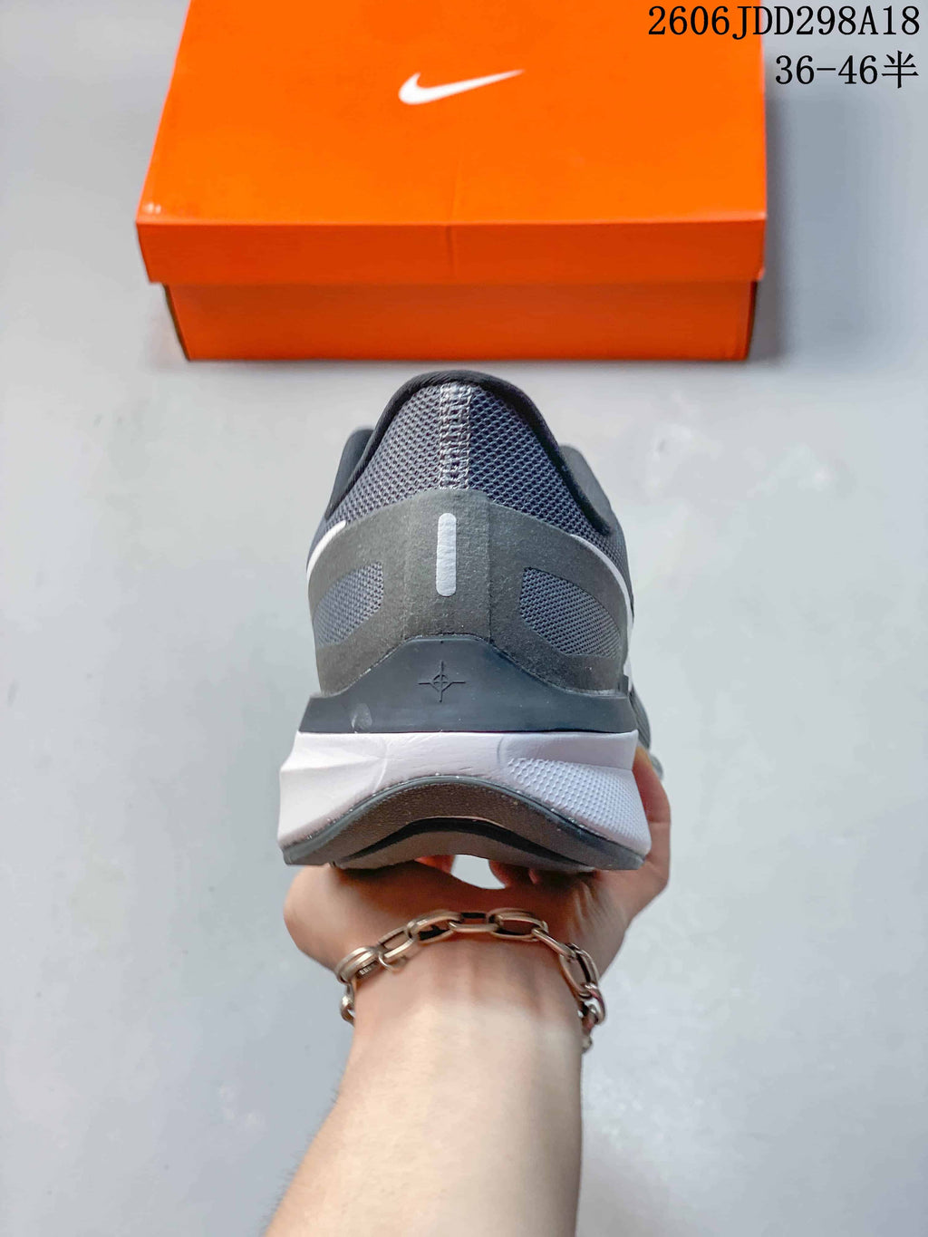 Rear view of the gray Nike sneaker showing the padded heel structure and layered midsole.