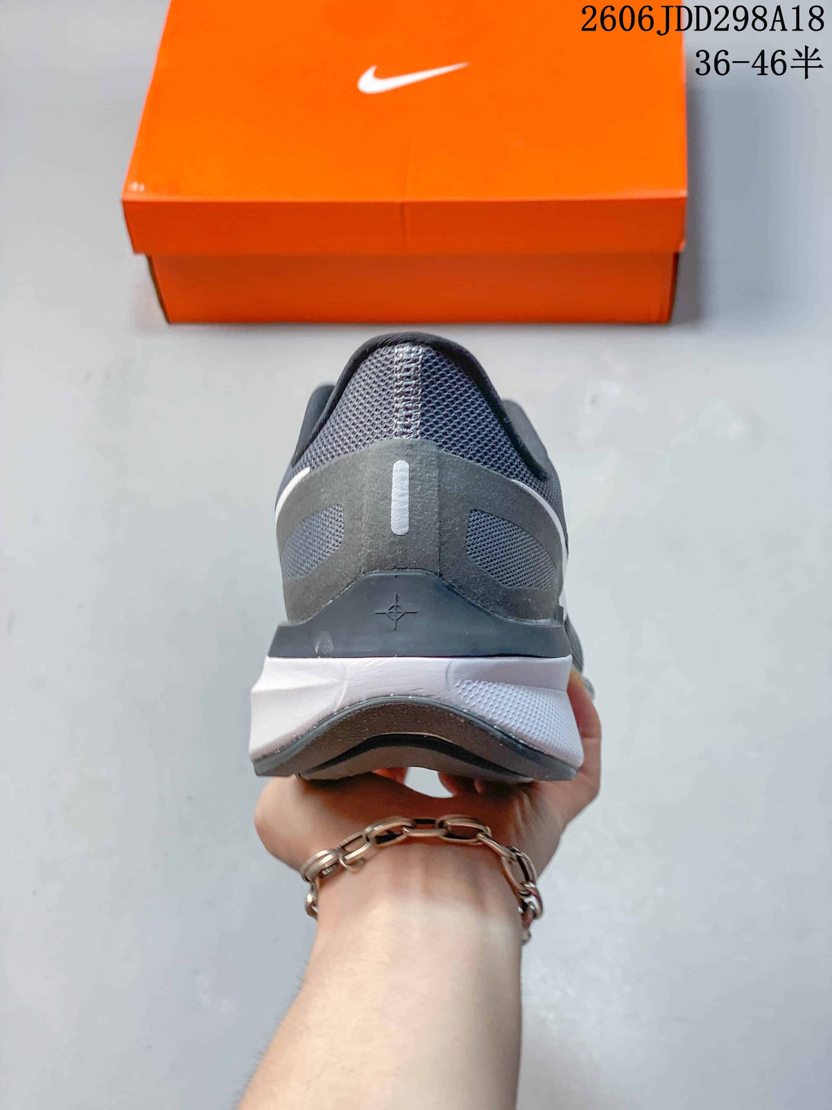 Rear view of the gray Nike sneaker showing the padded heel structure and layered midsole.