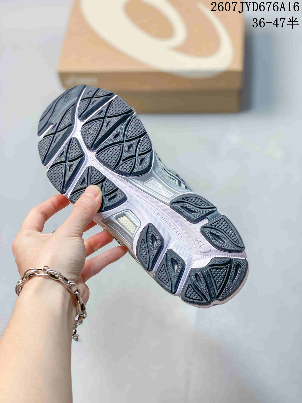 Close view of the sneaker outsole showing segmented dark rubber traction sections and a light midsole.