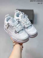 White low-top kids basketball sneakers shown from a front three-quarter angle with Jumpman branding, mesh-style panels, and side cage details.