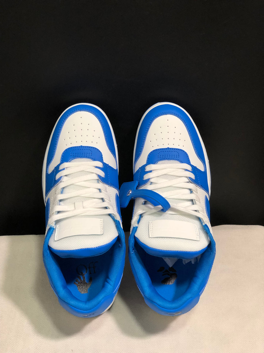 Top view showing the white perforated toe boxes, blue overlays, tongues, and laces.