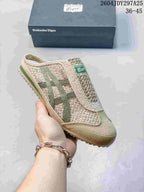 Angled side view of the beige and green Onitsuka Tiger Mexico 66 Sabot sneaker with its shoe box in the background.