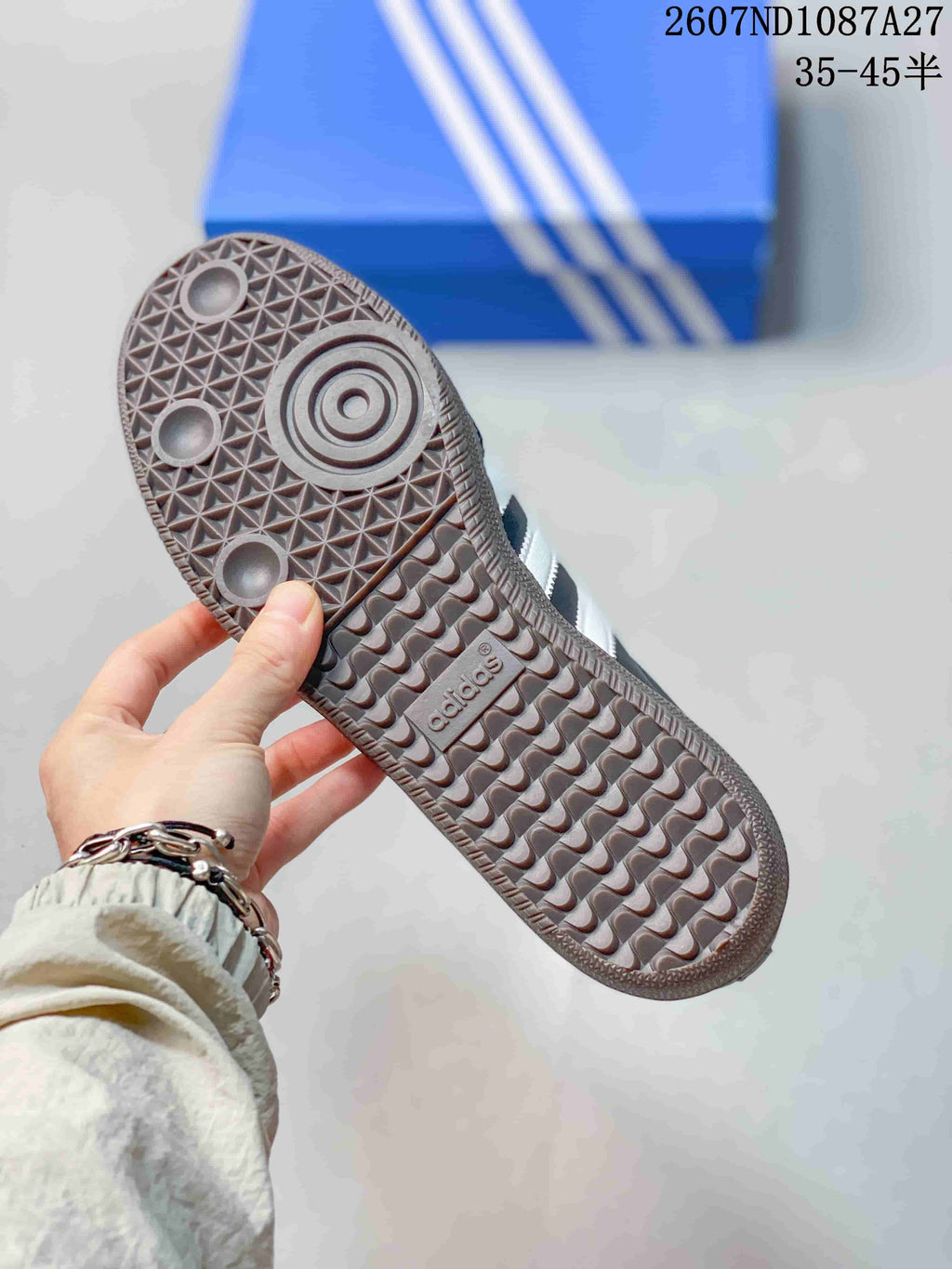 Close-up of the patterned gum-colored outsole showing circular forefoot details and adidas branding.