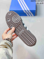 Close-up of the patterned gum-colored outsole showing circular forefoot details and adidas branding.
