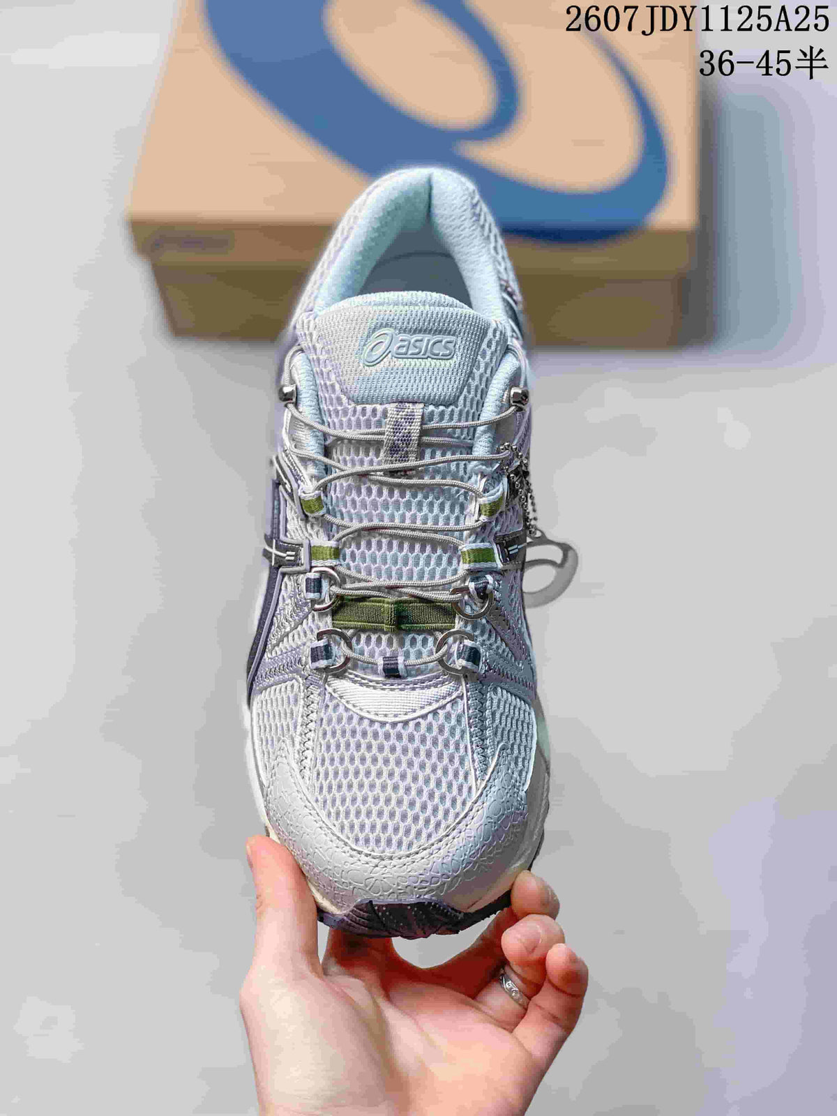 Top view of the sneaker showing the textured upper, layered lace system, and ASICS tongue branding; image text shows style code 1125A25 and size range 36–45.