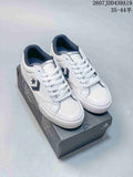 Pair of white Converse All Star low-top sneakers displayed on a branded shoe box, showing dark star-and-chevron side details.