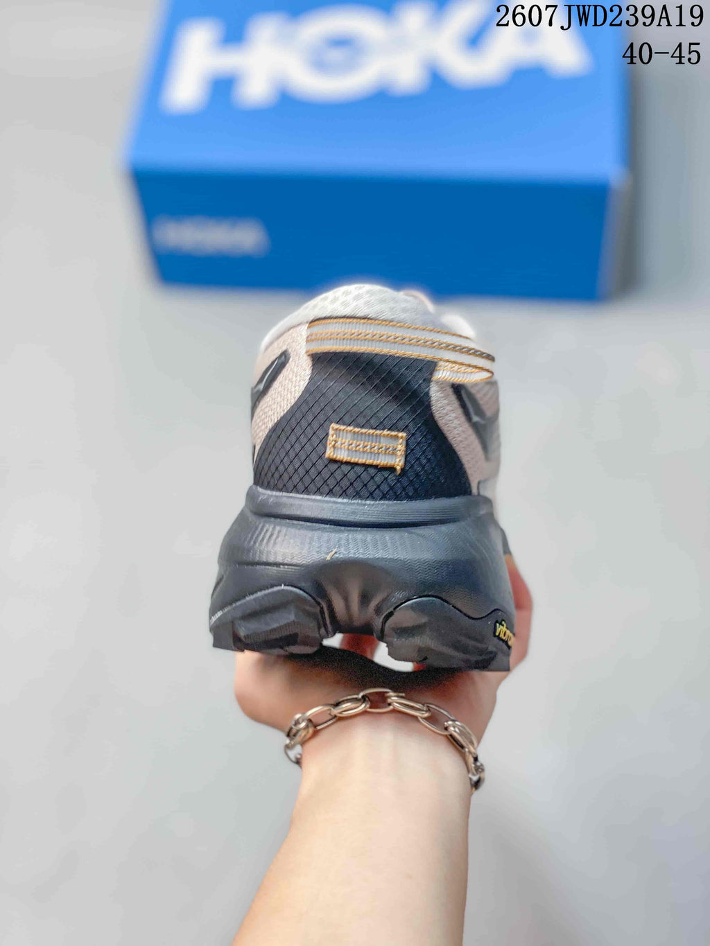 Rear view of a HOKA running shoe showing the padded heel, dark heel structure, and textured upper.