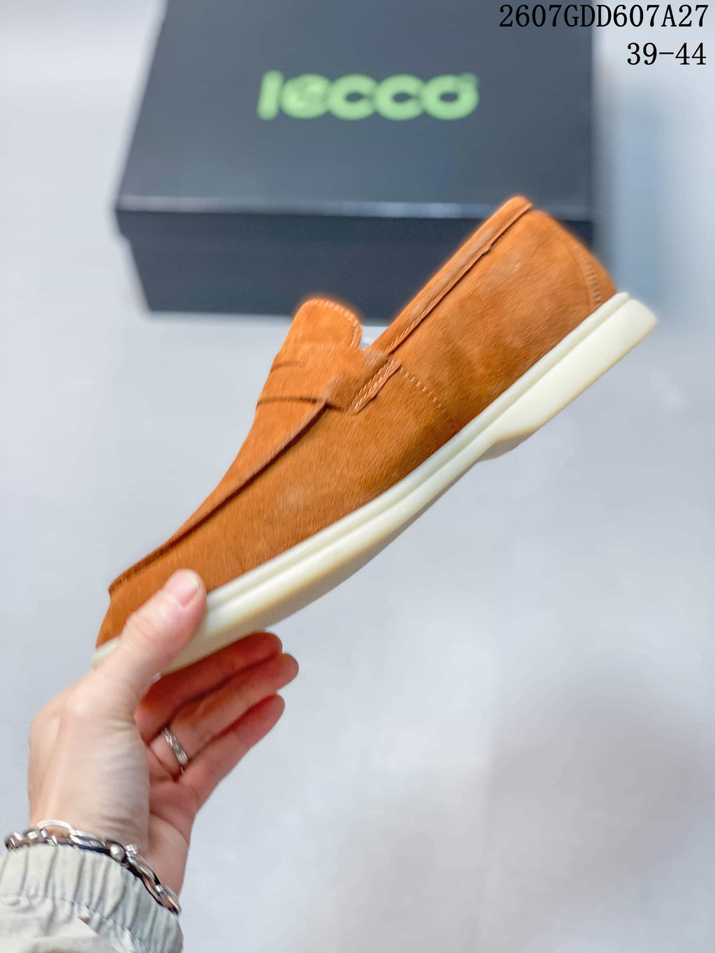 Side profile of a brown slip-on loafer showing the penny strap, stitched upper, and low-profile sole.