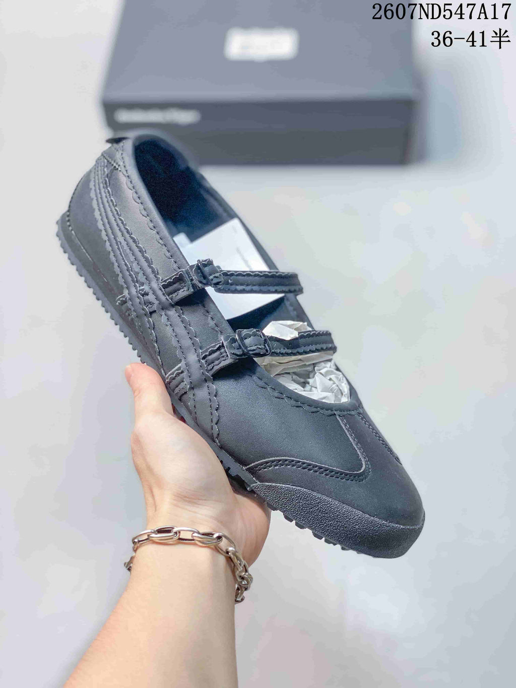 Black Mary Jane sneaker shown from an angled side view with two adjustable straps.