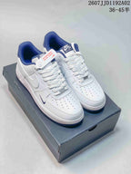 Pair of white and navy Nike Air Force 1 low-top sneakers on a shoebox