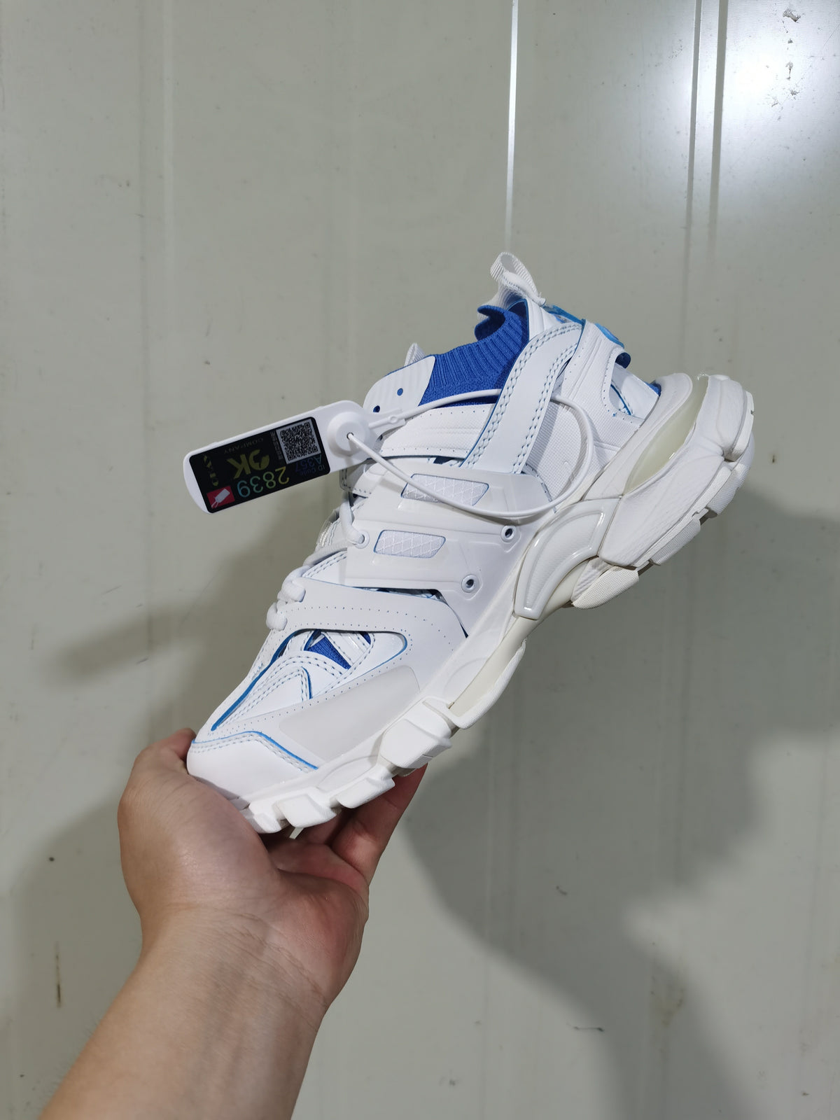 Rear and lateral view of the white and blue Balenciaga Track Sock sneaker, showing the layered heel structure, knitted collar and segmented outsole.