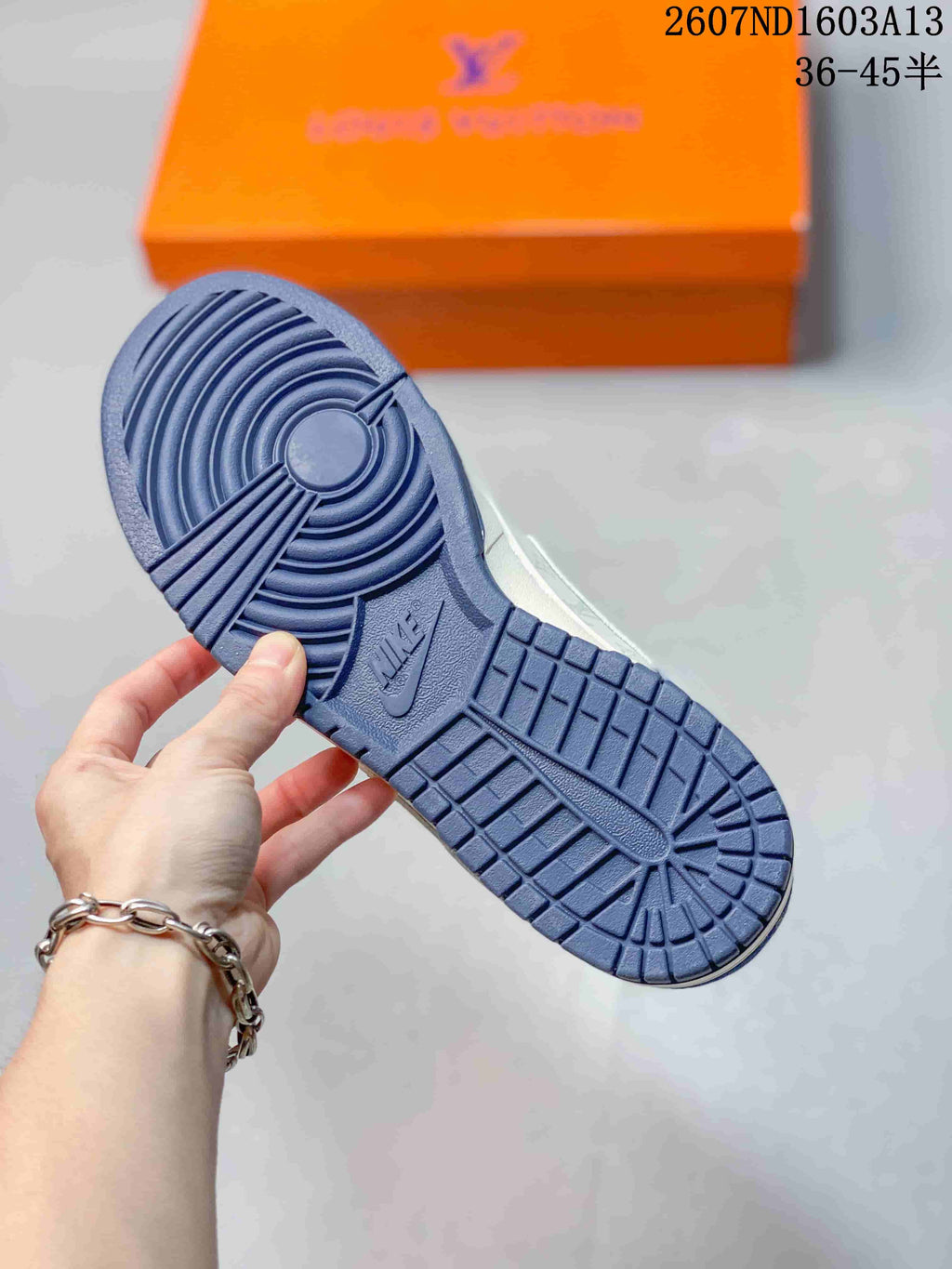 Underside view showing the blue rubber outsole with circular and block traction sections.