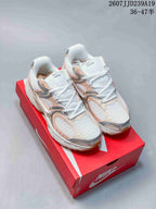 Pair of Nike V5 RNR sneakers in white, peach, and silver on a red Nike shoebox.
