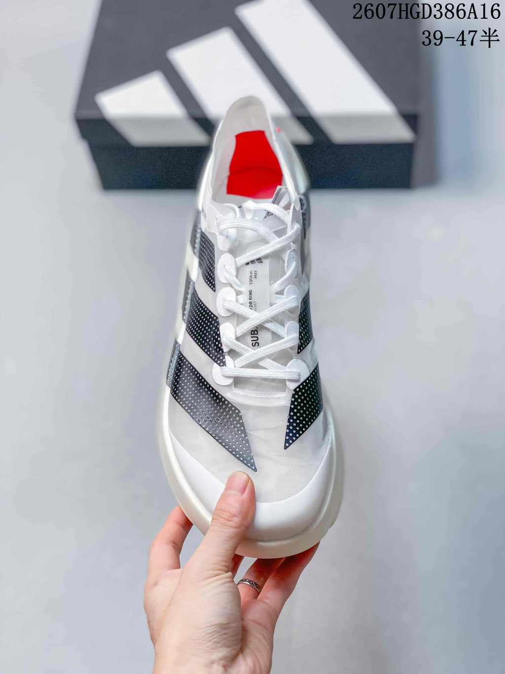 Top view showing the white laces, tongue, black stripe details, and red interior accent.