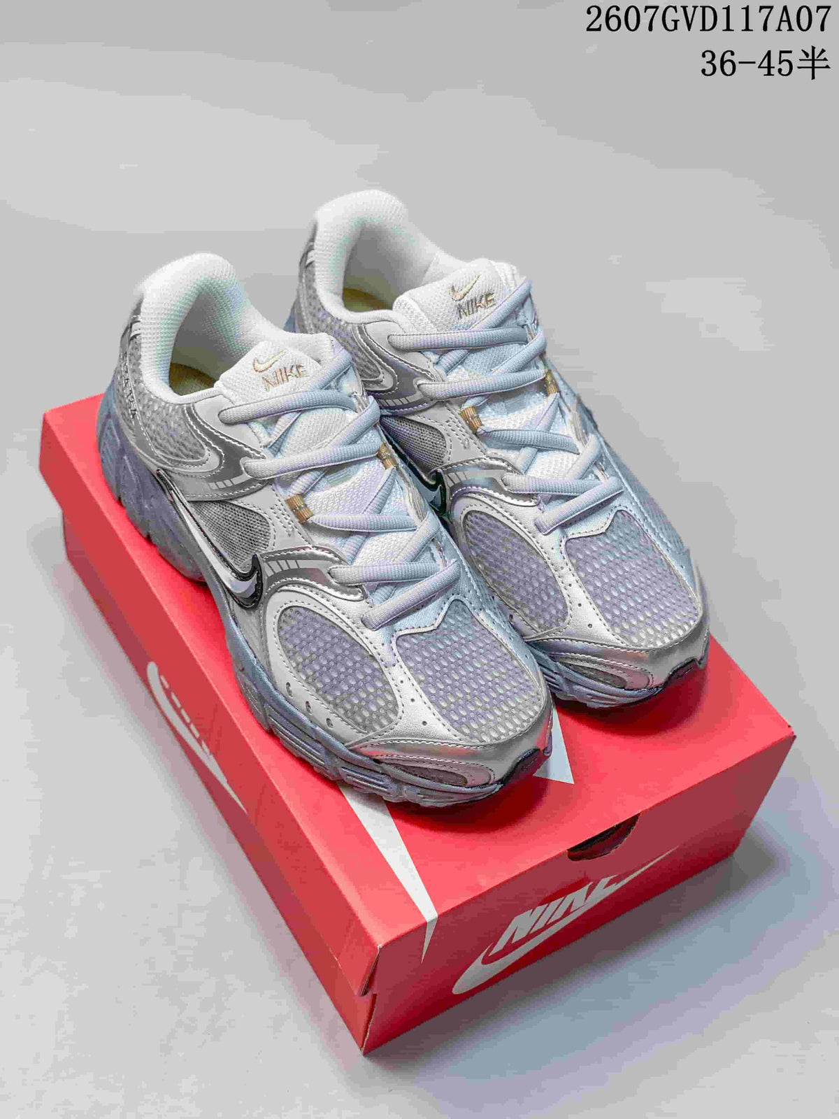 Pair of silver and gray Nike V5 RNR sneakers displayed on a red shoebox.