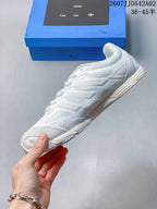 Side profile of the white sneaker showing layered panels and textured sections.