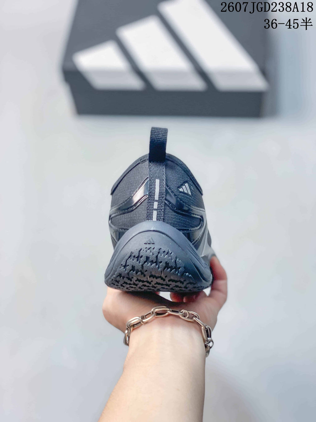 Rear view of the dark gray sneaker showing the heel pull tab, layered panels, and outsole pattern.