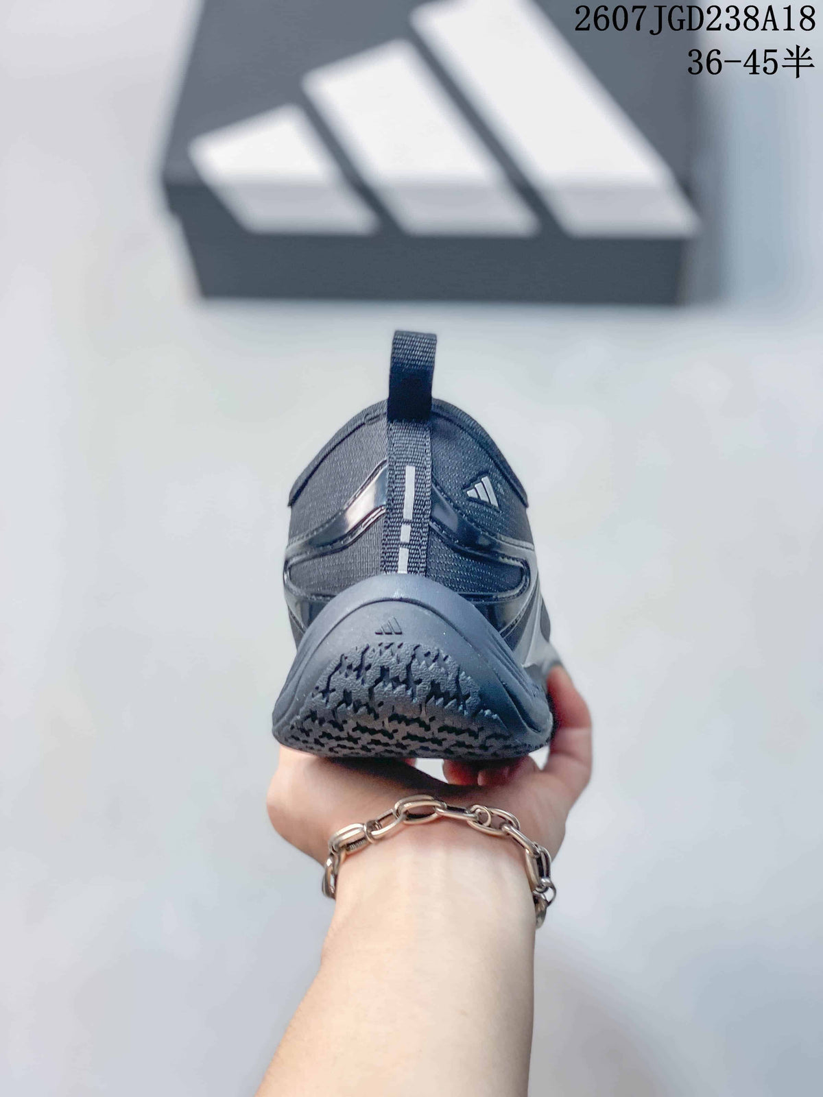 Rear view of the dark gray sneaker showing the heel pull tab, layered panels, and outsole pattern.